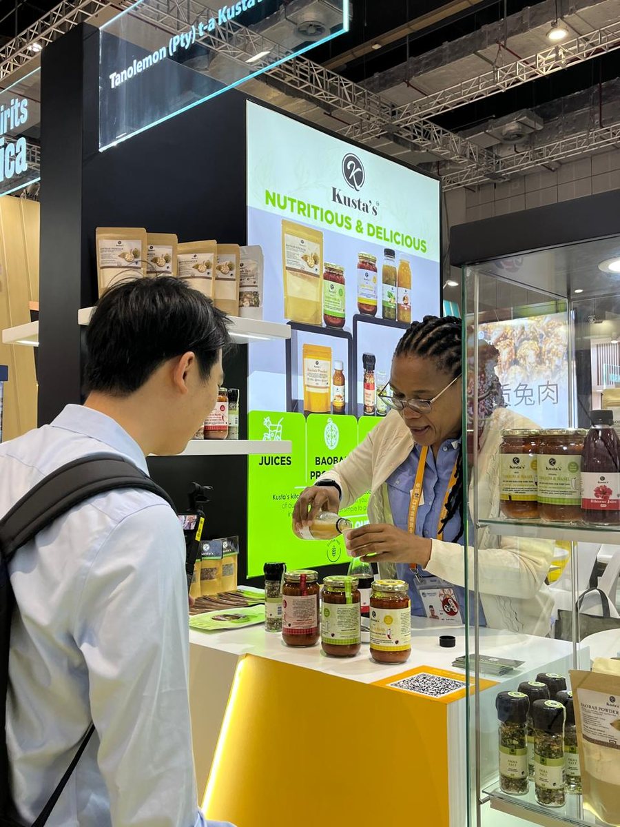 Kusta's founder serving a visitor at the Kusta's stand, China International Import Expo